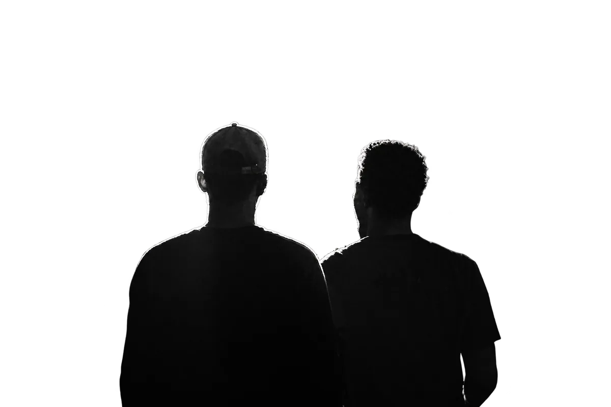 Two artists seen from behind, facing the crowd